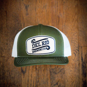A green and white hat with the words del rio brewing company on it.